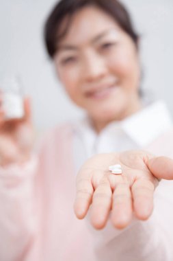 İlaç alan Asyalı kadını kapatın.