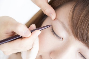 Güzellik salonunda makyaj yapan Asyalı güzel bir kadının yakın çekimi. 