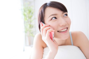 Genç bir kadın cep telefonuyla konuşuyor.