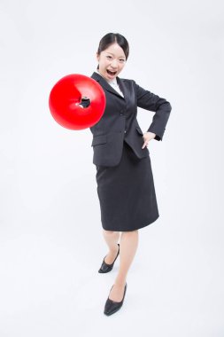 Megafonlu Asyalı iş kadını izole edilmiş arka planda stüdyoda duruyor. 