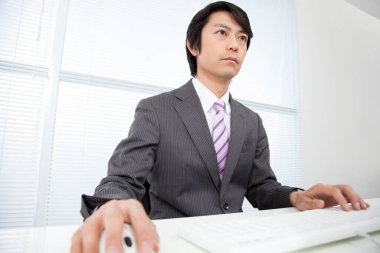 Ofiste çalışan kendinden emin genç Japon işadamı.