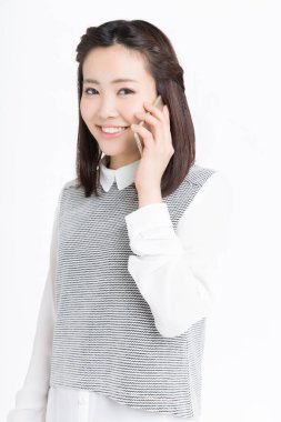 Akıllı telefondan konuşan güzel Japon kadının stüdyo portresi.