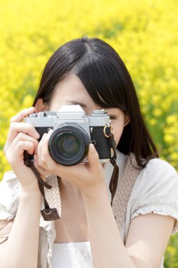 Genç kadın kamera açık havada ile fotoğraf çekmek