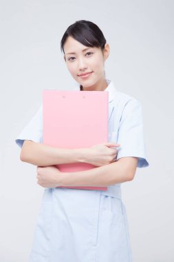 Bayan hemşire klasörü tutuyor, stüdyo fotoğrafı.