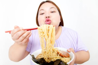 Şişman Asyalı kadın erişte yiyor. Stüdyo resmi