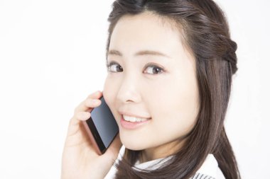 Akıllı telefondan konuşan güzel Japon kadının stüdyo portresi.