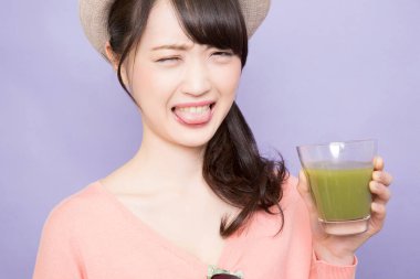 Elinde yeşil kibrit çayı tutan kadın.