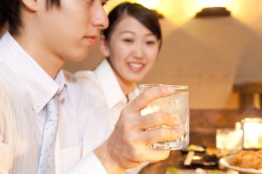 Restoranda su içen genç kadın ve erkek. 