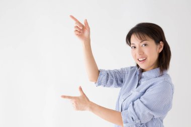 Asyalı kadın parmaklarıyla bir şeyi işaret ediyor. 