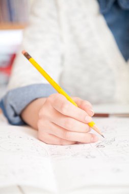 Kağıtlara çizim yapan bir kadın eli.