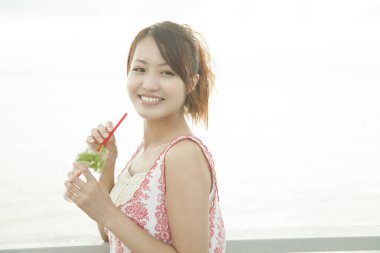 Genç bayan dışarıda kokteyl içiyor. 