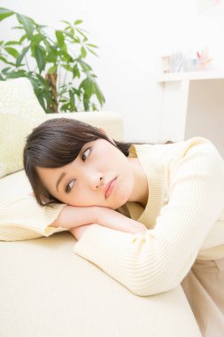 Evde sıkılmış Asyalı bir kadının portresi.