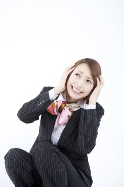 Baş ağrısı çeken takım elbiseli, gülümseyen bir kadın. 