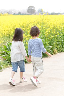 İki çocuk el ele yürüyorlar.