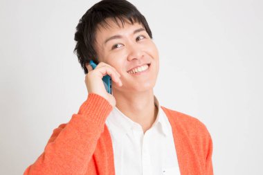 Sıradan giyinmiş Asyalı bir adamın portresi telefonda konuşuyor, stüdyo fotoğrafı.