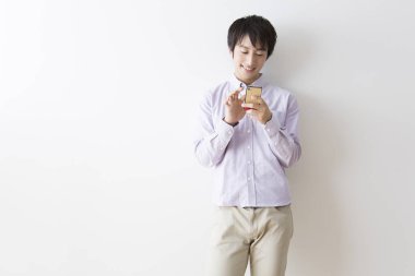 Duvarda akıllı telefon kullanan genç adam 