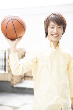 Basketbol topuyla poz veren Japon adamın portresi