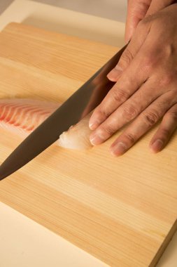 Şef bıçakla taze balık filetosu kesiyor.