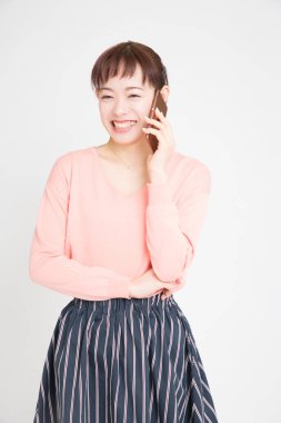 Telefonda konuşan Asyalı genç bir kadın.