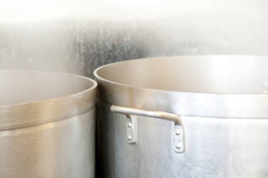 Büyük paslanmaz çelik tencereler parlak ticari mutfağın içinde buharlaşır.