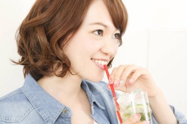 Güzel Japon kadın naneli ferahlatıcı soğuk içecek içiyor.