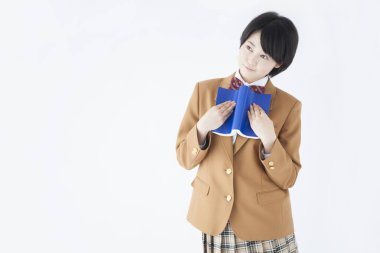 Asyalı liseli kız elinde kitapla, stüdyo fotoğrafı.