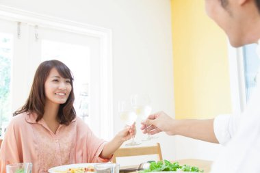 Asyalı çift masada kadeh kaldırıyor.