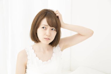 Güzel, uykulu genç bir kadının portresi aydınlık yatak odasının içinde.