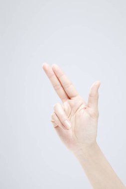 Beyaz arka planda el hareketi yapan kadınların yakın çekimi. 