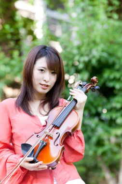 Kemanı olan genç Asyalı kadın.