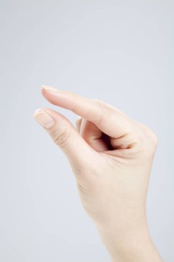 Beyaz arka planda el hareketi yapan kadınların yakın çekimi. 