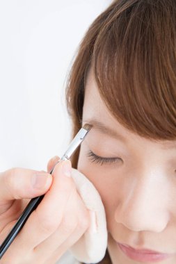 Güzellik salonunda makyaj yapan Asyalı güzel bir kadının yakın çekimi. 