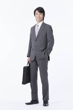 Beyaz arka planda duran Asyalı genç iş adamı.