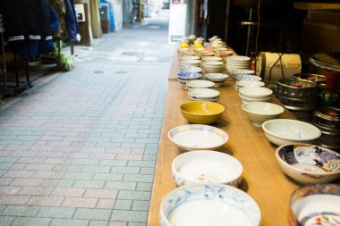 Seramik kaseler, sokak kenarındaki ahşap masa.