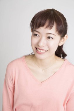 Beyaz arka planda poz veren Asyalı kadın 