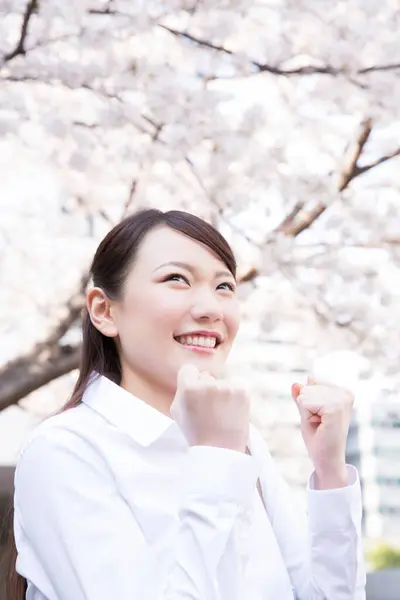 young asian woman with cherry blossom with fists up