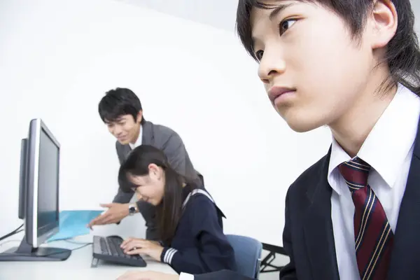 学校で教師と一緒に勉強している日本の女の子と男の子の肖像画 — ストック写真