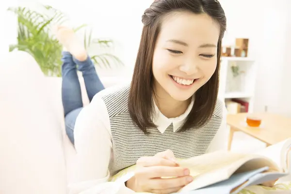 Glimlachende Jong Japans Vrouw Lezen Boek Thuis — Stockfoto