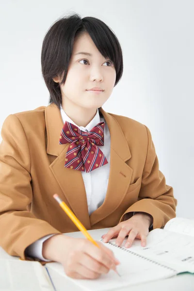 Ασιάτισσα Που Φοράει Σχολική Στολή Και Σπουδάζει Στο Γραφείο — Φωτογραφία Αρχείου