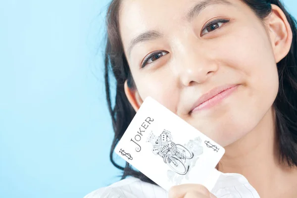 asian woman holding joker card with smile