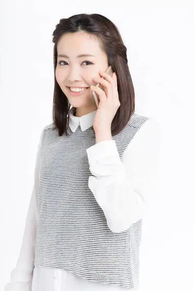 Akıllı telefondan konuşan güzel Japon kadının stüdyo portresi.