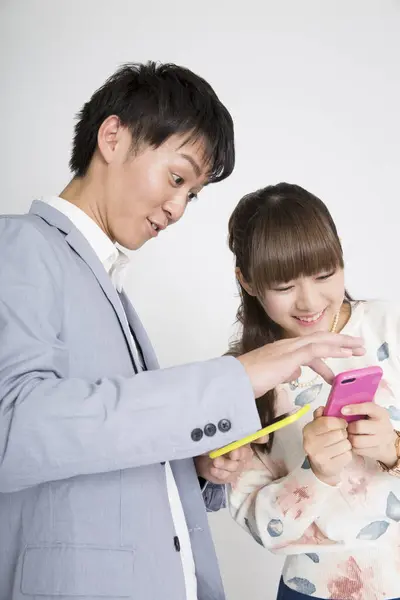 Young Couple Using Smart Phones Studio — Stock Photo, Image