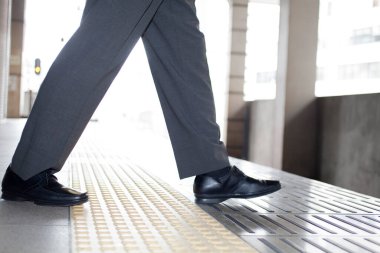 İş adamı tren peronunda duruyor. 