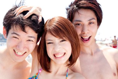 Kumsaldaki mutlu Asyalı arkadaşlar