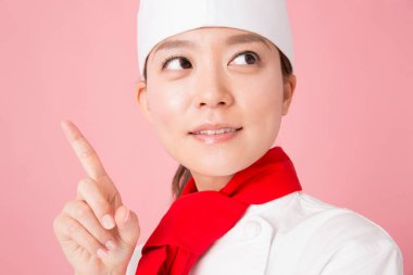 Genç bir kadın şef üniforması giyiyor.