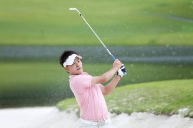 Güzel güneşli bir günde golf oynayan bir golfçü.