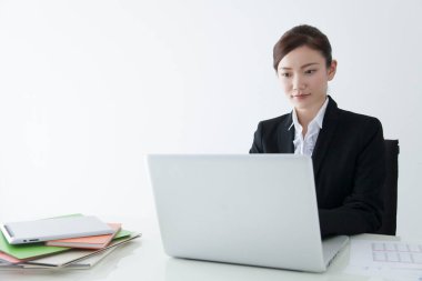 Dizüstü bilgisayar kullanan kendine güvenen Japon iş kadını.