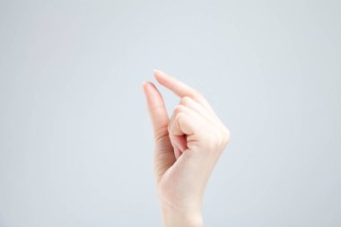 Beyaz arka planda el hareketi yapan kadınların yakın çekimi. 