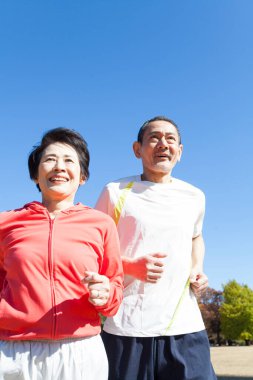 Asyalı son sınıf çifti parkta koşuyor.