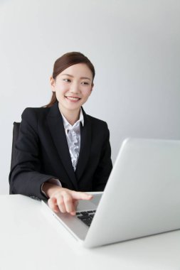 Dizüstü bilgisayar kullanan kendine güvenen Japon iş kadını.